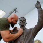 Sculptor Agon Qosa works on a statue of Britain’s former