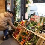 A customer shops for vegetables at gourmet grocery store Andreas,