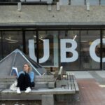 A woman reads outside the UBC Life Building at the
