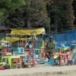 An Indian security force personnel walks amid toppled chairs and