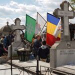 People queue up at a tomb bearing the flag with