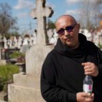 People queue up at a tomb bearing the flag with