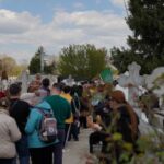 People queue up at a tomb bearing the flag with