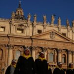 Nuns walk in front of St. Peter’s Basilica in St.