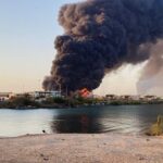 A view shows a large plume of smoke and fire