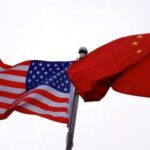 Chinese and U.S. flags flutter outside the building of an