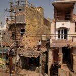 A man stands amidst the debris on the roof of