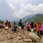 People wait as authorities stopped them returning to their villages