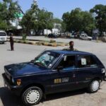 Basharat Abbasi cleans his car while waiting for customers to