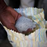 FILE PHOTO: A man displays a coltan ore at the