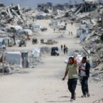 Palestinians make their way with belongings as they flee their