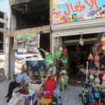 A man sits next to his renovated store in Nabatieh’s