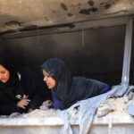 Palestinians search for casualties at the site of an Israeli