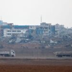 Trucks loaded with aid drive on the Israel-Gaza border as