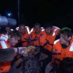 An Israeli solider passes food to those onboard the Gaza-bound
