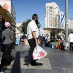 People shop in Jerusalem following an Israeli strike in Iran