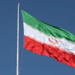 The Iranian flag is seen flying over a street in