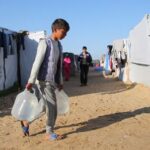 Palestinians wait to collect water in Khan Younis