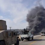 FILE PHOTO: Smoke rises while members of the Syrian forces