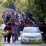 FILE PHOTO: Migrants walk towards the Austrian border after they