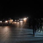 Members of Syrian security forces stand on the side of