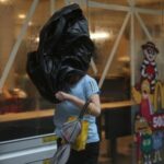 A woman braves strong winds as Typhoon Wipha approaches, in Hong Kong