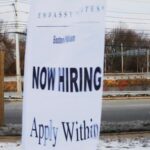 A sign advertises open jobs at an Embassy Suites hotel