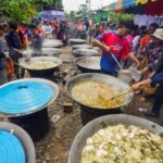 People evacuated from Pong Tuek village queue for food at