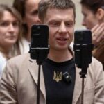 Lawmaker Oleksii Honcharenko holds smartphones as he live streams a