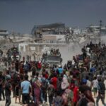 Palestinians carry aid supplies that entered Gaza through Israel, in