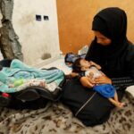 Palestinian mother Amira Muteir holds her five-month-old baby Ammar, whom