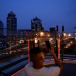 A person takes pictures on a terrace of a shopping