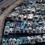 Fishing boats are docked inside a port, as Typhoon Podul