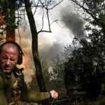 A Ukrainian serviceman fires a howitzer towards Russian troops at