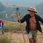 Residents clear bushes and vegetation to prevent wildfires from reaching