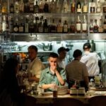Employees work in the open kitchen of a restaurant in