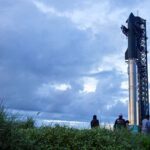 Spectators watch from the dunes as preparations to launch a