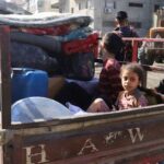Palestinians inspect the site of an overnight Israeli strike on