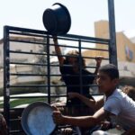 Palestinians wait to receive food from a charity kitchen, in