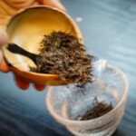 A view shows tea leaves in a bowl and a