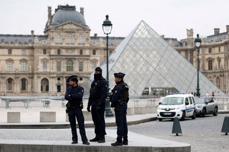 FILE PHOTO: Police stand near the pyramid of the Louvre