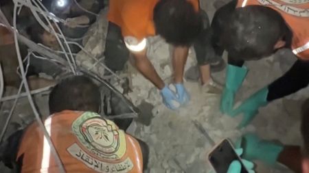 Rescuers work to free people trapped in rubble after an