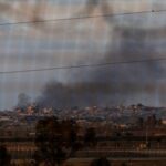 Destruction in Gaza can be seen through the fence of