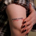 Elona Leleko, 31-years-old, shows a tattoo with the inscription ‘I’m