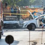 A police officer stands at the site of a blast
