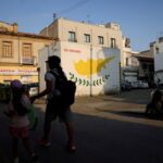 FILE PHOTO: People walk next to a Cypriot flag painted