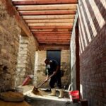 An Egyptian worker collects sand on-site at the Darb al-Labbana