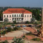 Cars move next to the presidential palace in Bissau