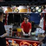 Dimi Heryxlim, 15, a social media content creator, serves customers