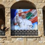 FILE PHOTO: A woman stands next to a poster depicting